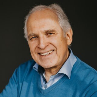 Zeichner und Autor Werner Tiki Küstenmacher lacht in die Kamera. 