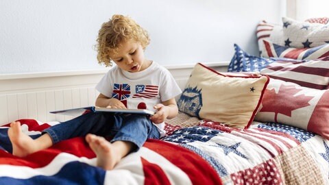 Ein kleiner junge betrachtet ein Bilderbucht: Kinder lernen ihre Muttersprache im sozialen Hin und Her mit Eltern, Geschwistern und anderen Bezugspersonen. Sobald sie Worte beherrschen, sprechen sie auch laut mit sich selbst, etwa beim Spielen. Die innere Stimme dient dazu, Pläne auszubrüten und Probleme zu lösen. Sie ist ein Instrument, das uns hilft, das Leben zu meistern.