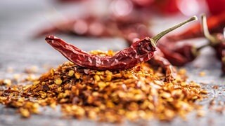 Gemahlene scharfe Paprikaschoten auf dem Küchentisch: Warum bekommt man von scharfem Essen einen Schweißausbruch?