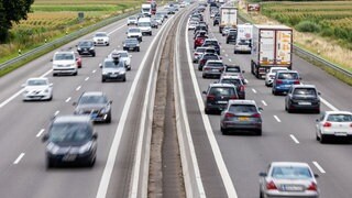 Autos fahren im zäh fließenden Verkehr über eine Autobahn.