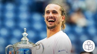 Alexander Zverev posiert mit dem Pokal. Er hat das Tennis·turnier US Open gewonnen hat. Rechts das SWR Logo für Leichte Sprache.