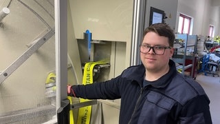Dirk Rosenbaum steht an der Maschine, die die Feuerwehrschläuche in Nierstein reinigt