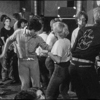 Ein Schwarz-Weiß-Bild. Junge Menschen tanzen Rock ’n’ Roll.