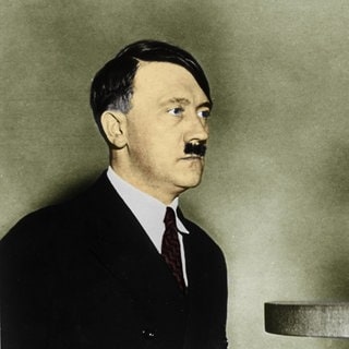 Adolf Hitler vor einem Radio-Mikrofon. Digital kolorierte Aufnahme aus dem Jahr 1933.