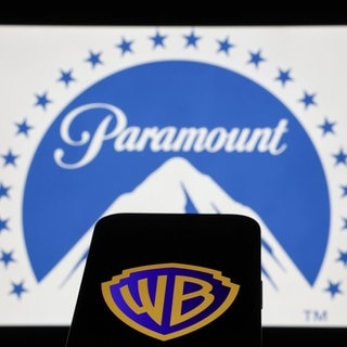 Das Paramount-Logo auf einem Laptop-Bildschirm und das Warner Bros-Logo auf einem Telefonbildschirm.