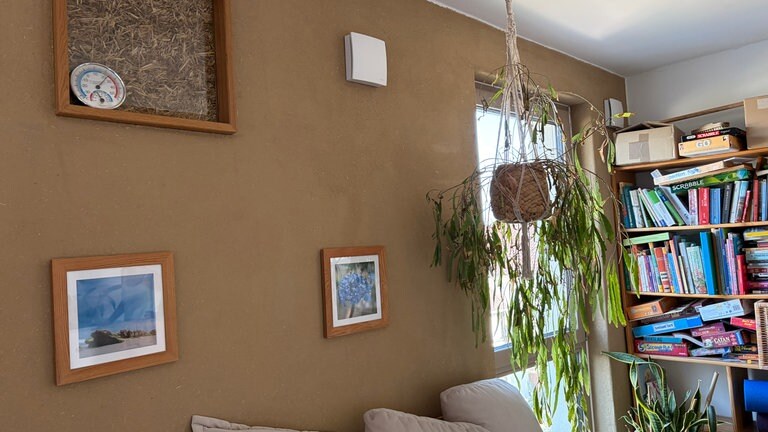 Das Haus wurde aus Holz, Lehm und Stroh gebaut. In einem Gemeinschaftswohnzimmer ist eine Glasscheibe eingelassen, durch die man die dahinterliegende Strohwand erkennen kann.