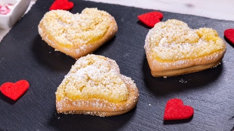 Nach dem Backen liegen die Herzen schön angerichtet auf einer schwarzen Schieferplatte.