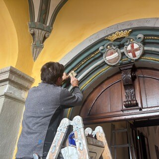 Ein Restaurator, der Blattgold am Seiteneingang im Torbogen anbringt. Das Freiburger Augustinermuseum wird am Donnerstag wiedereröffnet.