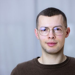 SWR-Reporter steht in Großraumbüro