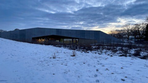 Ein niedriges Bauwerk in der Dämmerung: Das Heidengrabenzentrum bietet bei seiner Vollmondwanderung Natur und Wissenswertes über die Kelten bei Grabenstetten.