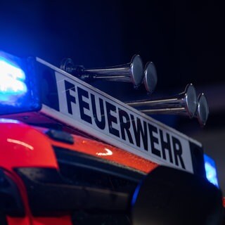 Ein Einsatzfahrzeug der Feuerwehr steht mit Blaulicht (Symbolbild)