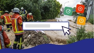 Feuerwehrleute stehen an einer überfluteten Straße.