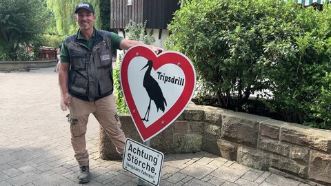 Ein Mann hält das wiederaufgetauchte Storchen-Schild von Tripsdrill in den Händen.