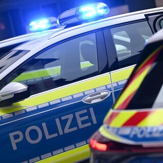 Mehrere Polizeiautos stehen mit eingeschaltetem Blaulicht nebeneinander