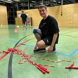 Lukas Rohfleisch kniet vor Springseilen in der Sporthalle vom TS Ottersweier. Er trainiert für die nächste Meisterschaft im Rope Skipping.