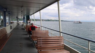 Pendlerin sitzt auf einer Bank auf der Bodenseefähre.