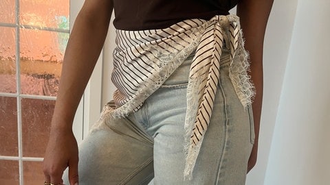 Tuch wird um die Jeans gebunden