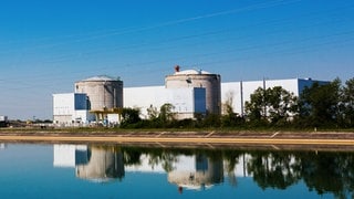 Die beiden Reaktorgebäude des Atomkraftwerks Fessenheim und eine anliegende Halle sind aus der Entfernung im Rheintal zu sehen (Archivbild).