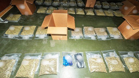 Drogen liegen in Klarsichtbeuteln auf dem Boden: Bei umfangreichen Durchsuchungen wurden dutzende Kilogramm Betäubungsmittel sichergestellt.