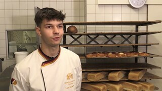 Brezelkönig Luca Stadelhofer steht in der Bäckerei und spricht in die Kamera.