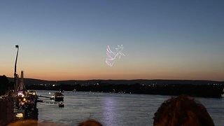 Eine von Drohnen geforme Friedenstaube am Himmel über dem Rhein in Mainz