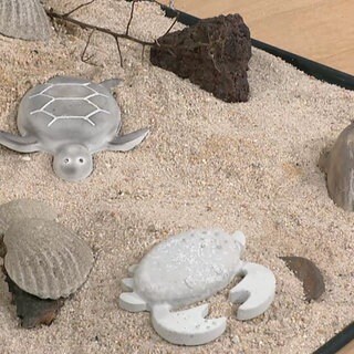 Betonfiguren im Sand