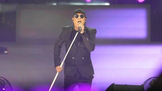 Sänger Peter Schilling singt bei einem Konzert in Frankfurt. Er trägt eine schwarze Kappe und einen schwarzen Anzug.