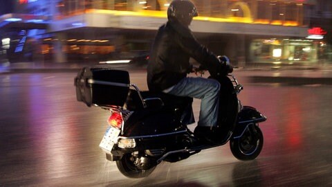 Ein Mann fährt auf seinem Motorroller durch die Nacht. In Mainz ist ein Rollerfahrer vor einer Polizeikontrolle geflohen und hat dann einen Unfall gebaut (Symbolbild)