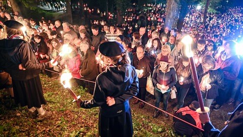 Viele Menschen standen nach einer Prozession von der Basilika ausgehend mit Kerzen in der Hand auf dem Kreuzberg.