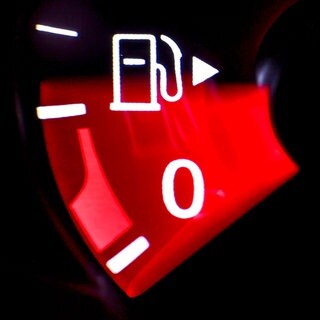 Die Nadel einer Tankanzeige in einem VW Passat zeigt wenig Kraftstoff an. Tank-Apps werden bei hohen Spritpreisen viel genutzt: Autofaher versuchen durch Preisvergleiche Geld zu sparen. Wann lohnt ein Umweg? 