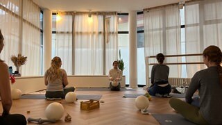 Frauen mit Baby finden Entspannung beim Yoga