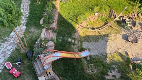 Der Gemeinschaftsgarten von oben mit der Rutsche und einer Vorrichtung für eine Hängematte.
