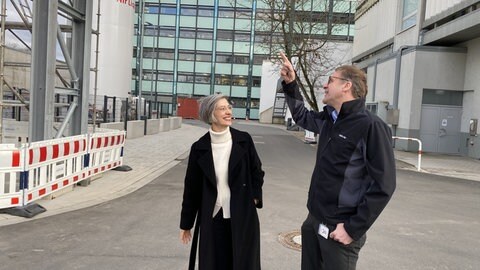 Bauingenieurin Sigtrud Rombach und AbbVie-Forschungsleiter Thomas Merdan betrachten die Fassade des neuen AbbVie-Laborgebäudes in Ludwigshafen