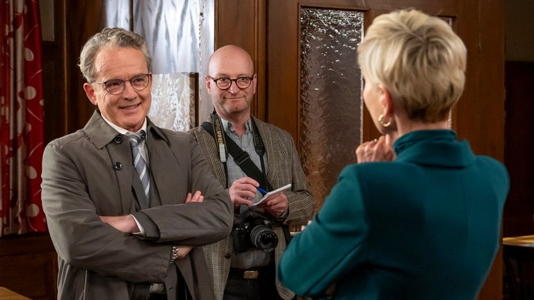 Bernhard, ein Journalist (Komparse) und Frau Dr. Siegel-Brack stehen sich im Löwen gegenüber