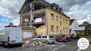 Ein Haus in Höhr-Grenzhausen ohne Giebelwand. Von der Straße aus kann man in die Zimmer sehen. Vor dem Haus steht ein Auto voller Bauschutt auf Motorhaube und Windschutzscheibe. Rechts unten das SWR-Logo für Leichte Sprache.