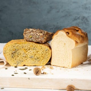 Körner-Nüsse-Saaten-Brot, Kürbis-Topfbrot und Toastbrot auf einem Schneidebrett. SWR1 Pfännle-Rezepte zum Motto "Bock auf Brot".