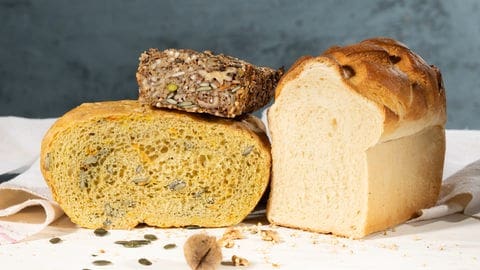 Körner-Nüsse-Saaten-Brot, Kürbis-Topfbrot und Toastbrot auf einem Schneidebrett. SWR1 Pfännle-Rezepte zum Motto "Bock auf Brot".