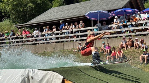 Eine Teilnehmerin des Waterslide-Wettkampfs hat es bis zum anderen Ende des Beckens geschafft. 