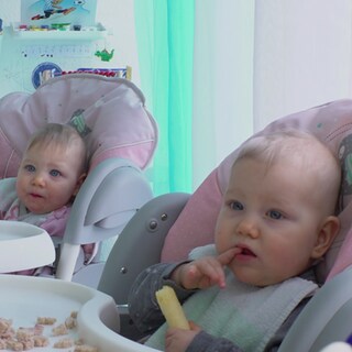 Zwei Babys schauen in die Kamera.