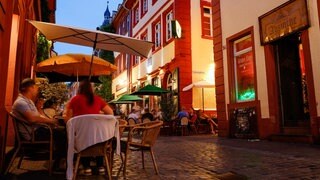 Menschen in der Heidelberger Innenstadt vor Kneipen in der Unteren Straße