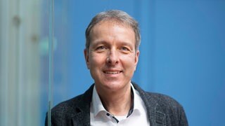 Kinderarzt Prof. Jörg Dötsch lächelt in die Kamera. Warum die ersten 1000 Tage im Leben eines Kindes so entscheidend sind und wie wir unsere Kinder sicher in die Zukunft begleiten und stärken können, erklärt Prof. Jörg Dötsch in SWR1 Leute