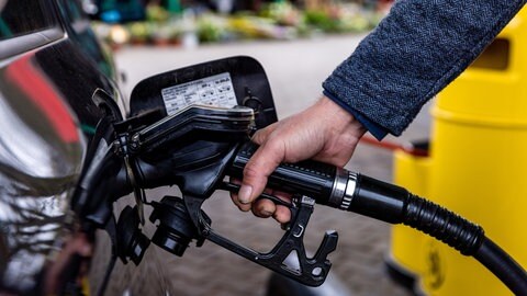Tanken an der Tankstelle bei Stau: Ein Tankrüssel steckt im Tankstutzen eines Autos.