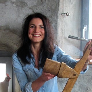 Heidi Huber im Spätzlemuseum. Sie zeigt eine Holzpresse für Spätzle.