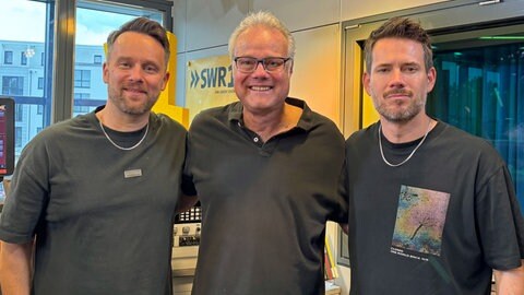 Kristoffer Hünecke (l.) und Johannes Strate (r.) von Revolverheld mit SWR1 Moderator Michael Lueg (Mitte) | Revolverheld feiern 20-jähriges Bandjubiläum mit Album "20"