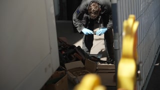 Ein Polizist fotografiert Gegenstände bei einer Razzia im US-Shop in Böblingen.