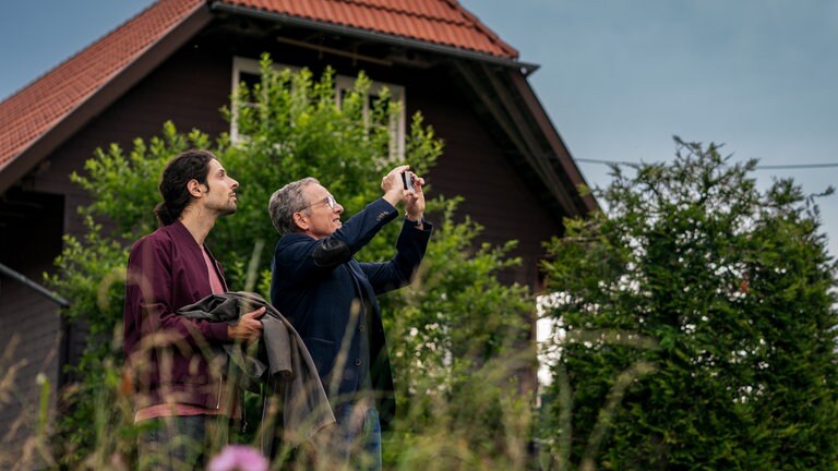 Albert (Alessio Hirschkorn) steht hinter Bernhard (Karsten Dörr), der etwas fotografiert